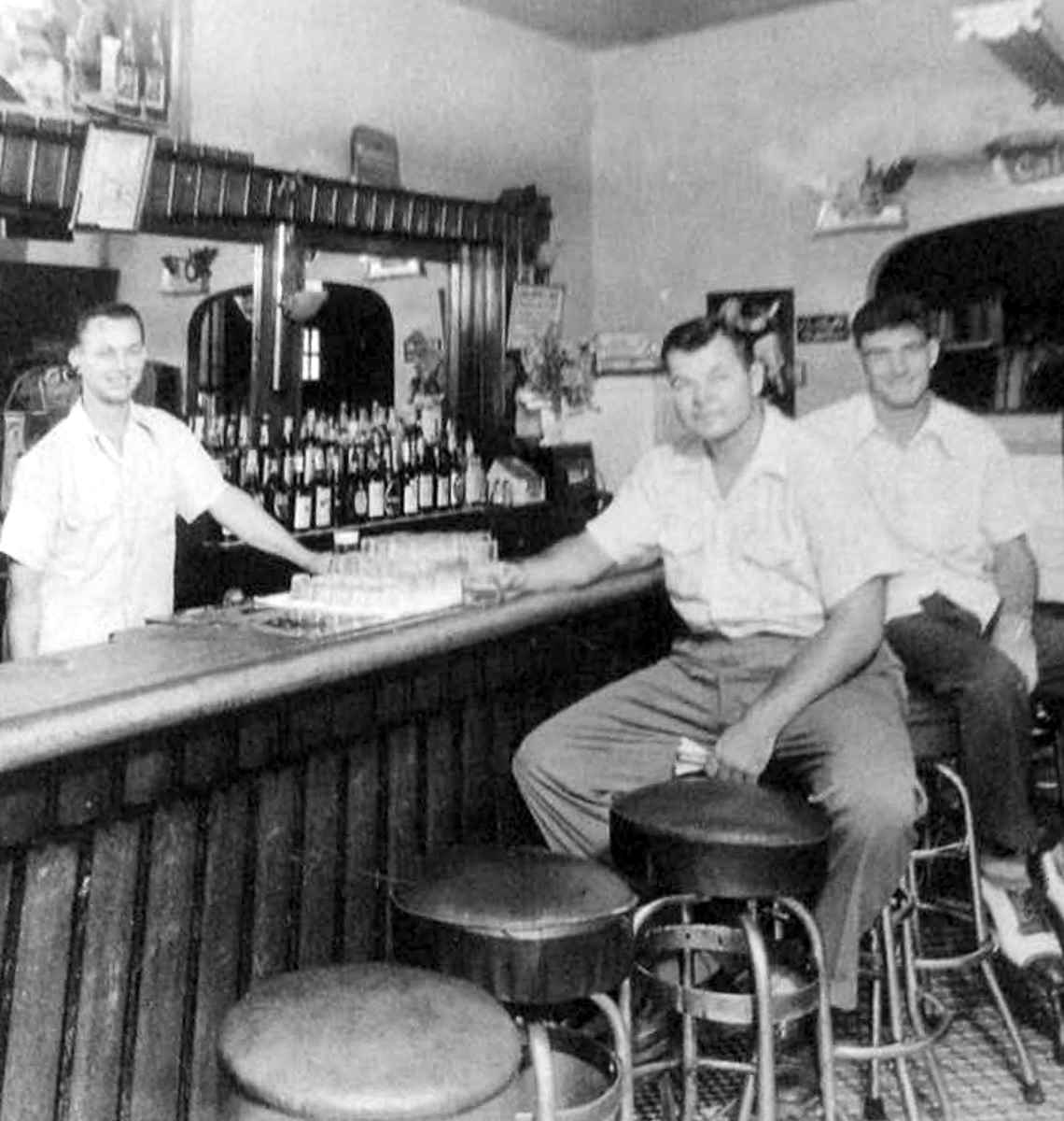 Joe Owsianka behind the bar at Martin & Owens, with two customers, late 1940s–early 1950s