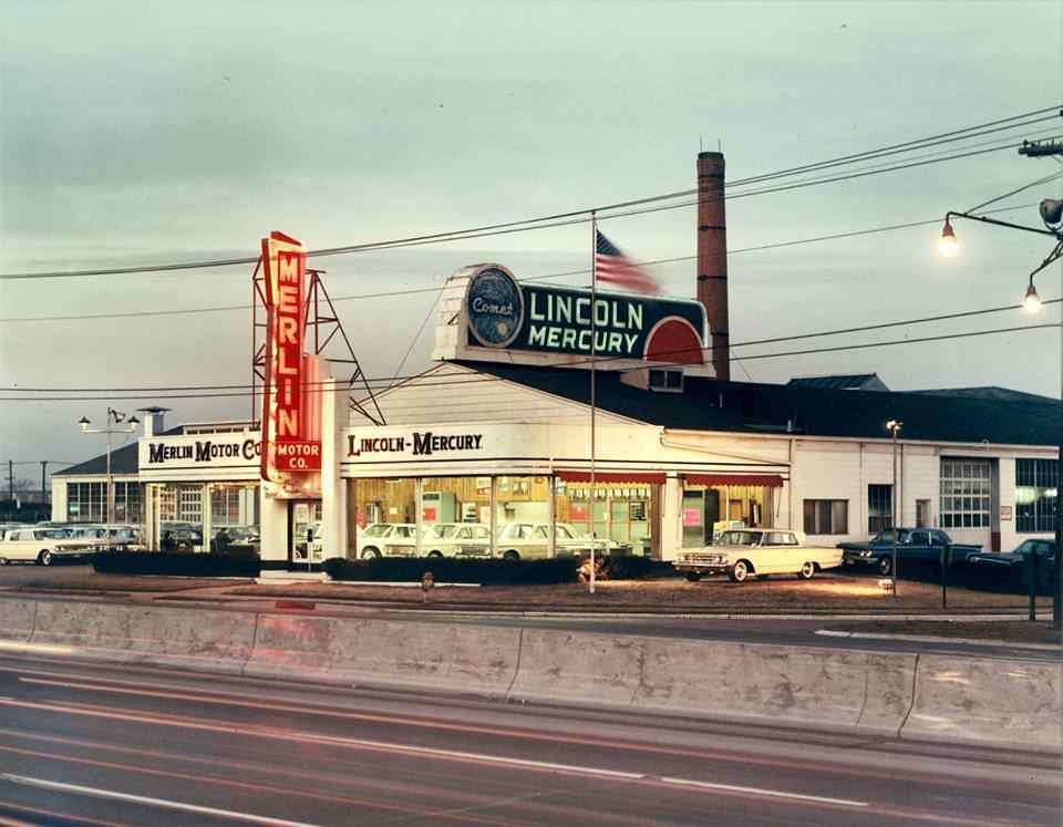 Merlin Motors exterior, 1960s — daylight, flag raised