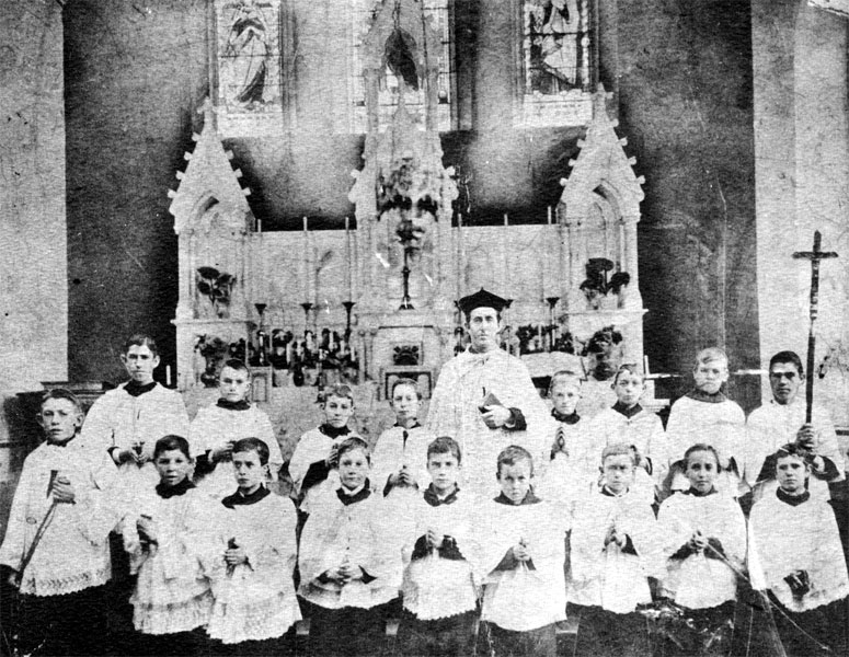 Fr. Maurice Bric pictured in front of Sacred Heart's main altar with an early group of altar boys