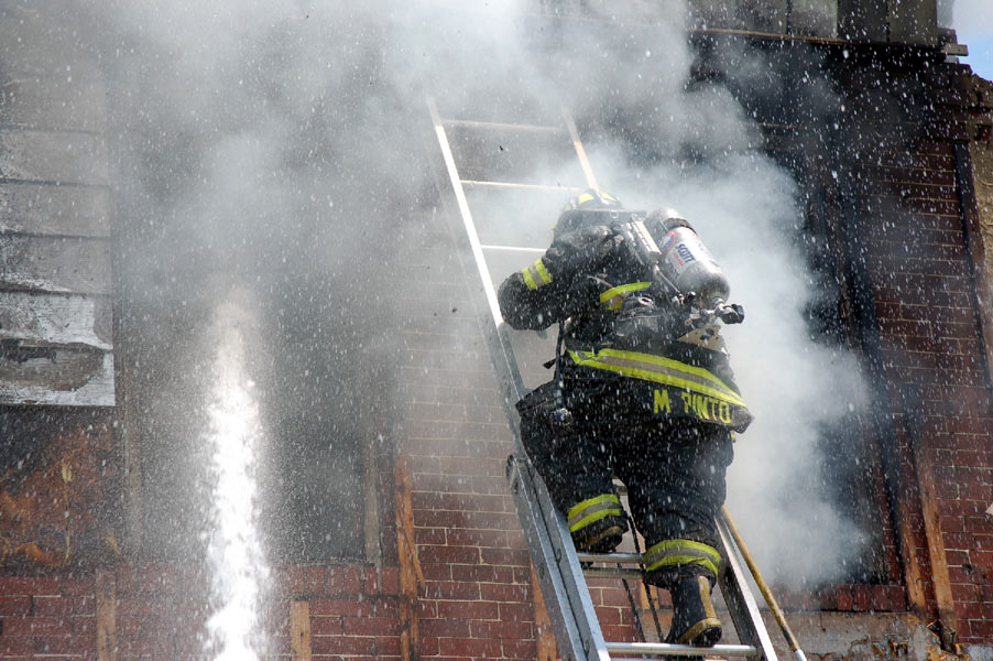 Ladder Company 1 fire fighter Mariano Pinto ascending ladder for ventilation and overhaul at 528 Borton Street, June 1, 2008