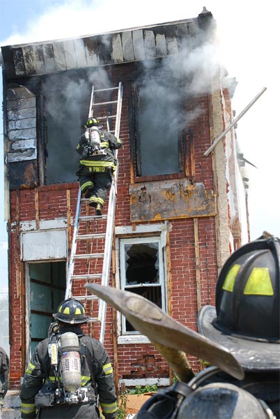 Ladder Company 1 fire fighter Mariano Pinto ascending ladder for ventilation and overhaul, 528 Borton Street fire, June 1, 2008