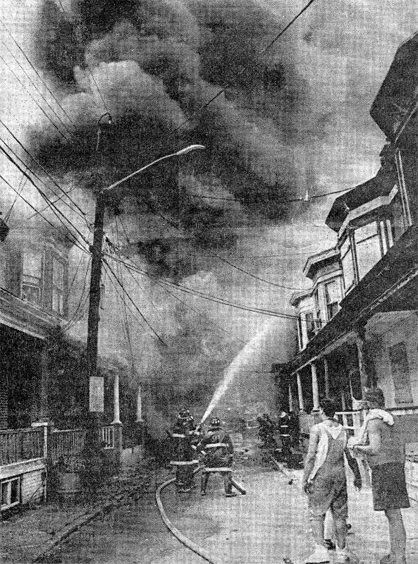 Firefighters train their hoses on a three-alarm fire in the 700 block of Grant Street, July 30, 1991
