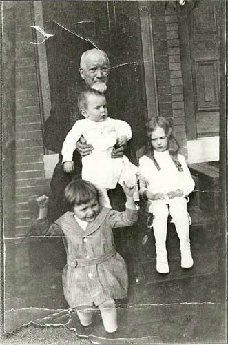 Louis Charles DeLisle with grandchildren on a porch