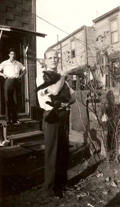Vincent A. Tydeman in the backyard of 2116 Howell Street, holding a cat