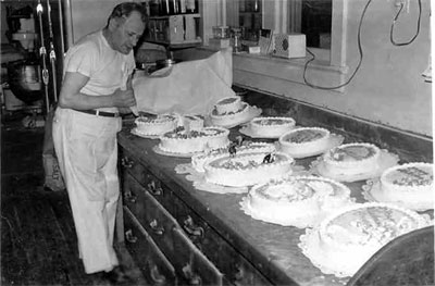 John H. Lang preparing cakes at Lang's Bakery, 2752 Federal Street, Camden NJ, early 1950s