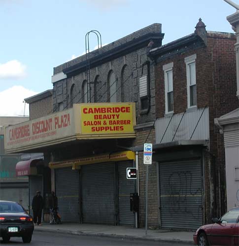 Close-up of the former Liberty Theater facade showing original art deco brickwork above the Cambridge Beauty Salon & Barber Supplies marquee, 2003