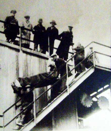 Body of one of the victims being taken down the stairway of the purifying box