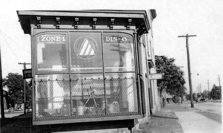 Looking southeast on Main Street at the intersection of Vine and North 2nd Streets, early 1940s, showing Taggart and Green plumbers serving as Civil Defense station