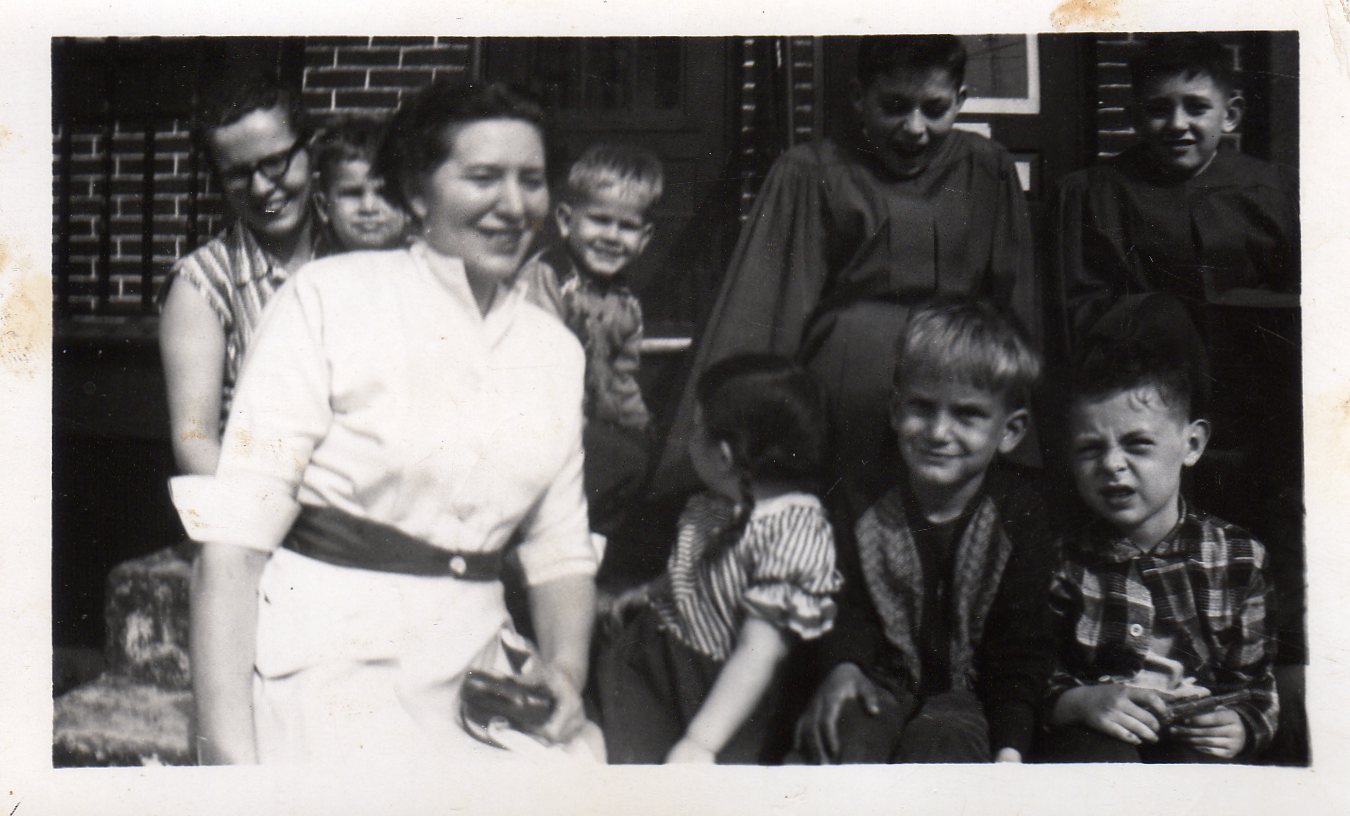 Left to right, rear: Mrs. McCullan and her blonde children, Raymond Becoskie and John Burns. Left to right, front: Theresa Burns and others. North 7th Street near Benny's market.