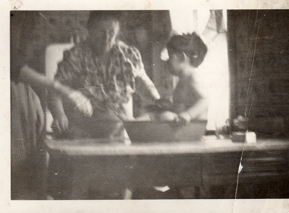 Kitchen of 625 Elm Street, 1947. Raymond H. Becoskie being bathed in basin by Grandmother Catherine Kennedy and his mother Mary Becoskie, while preparing apple pie.
