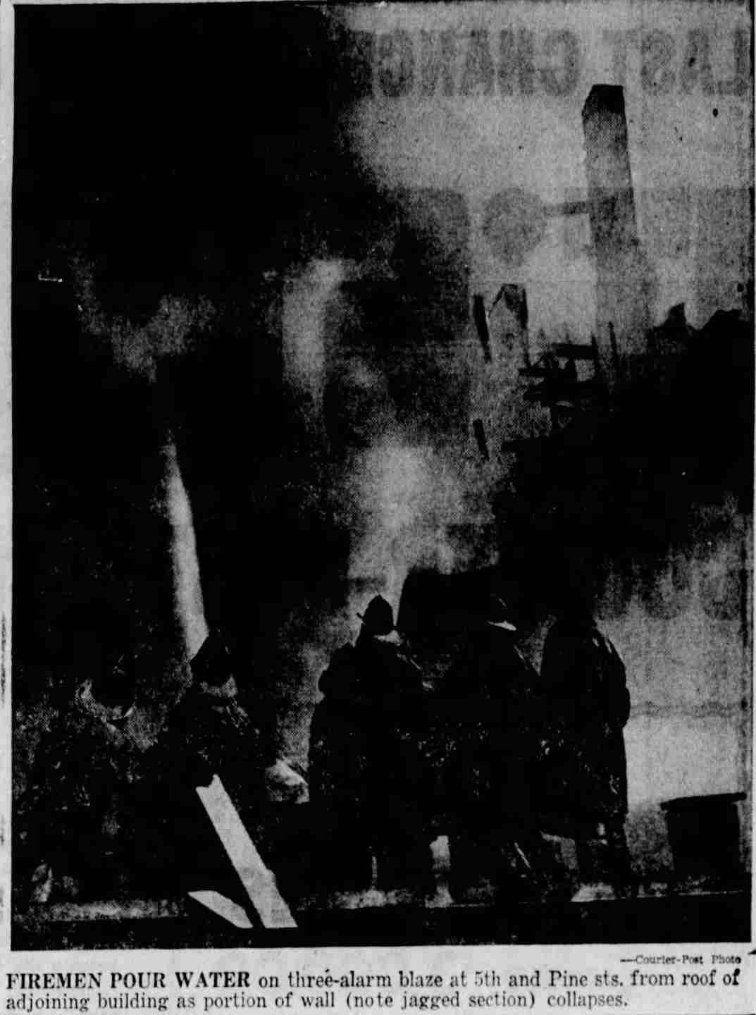 Firemen pour water on three-alarm blaze at 5th and Pine Streets, October 27, 1956