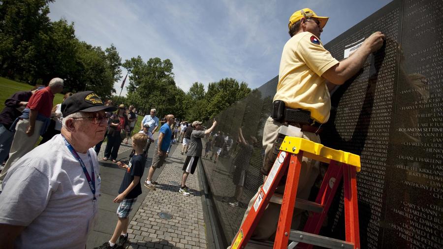 A Vietnam Memorial docent creates a pencil rubbing of Barrie Newton's name