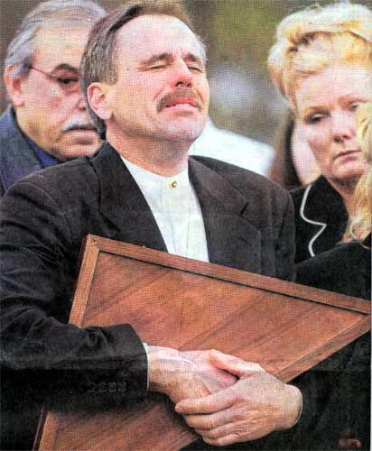 Stephen Froehlich holds tight to the flag that draped his son's casket at Gate of Heaven Cemetery, Camden Courier-Post, April 4, 2004