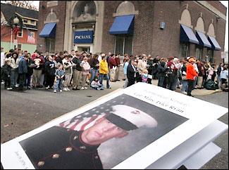 Mourners outside St. Mary's Church listen to the memorial service under way inside for Cpl. Marc Tyler Ryan, whose picture is on a program in the foreground.