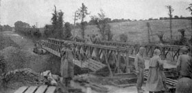 Men of the 12th Combat Engineer Battalion complete a Bailey Bridge over a ravine near Lambzellec, France, on the road to Brest