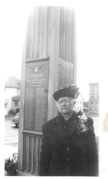 Sarah Mathys standing beside the Clark County Courthouse war memorial with Edwin Mathys' name on it