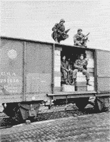 Troops on Troop Train 2980 with legs dangling outside boxcar doors