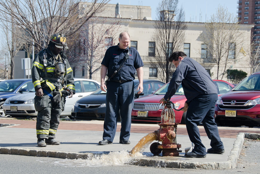Ken White, Howard Bennett, and Gabe Rivera flushing a hydrant on Rutgers Street, March 14, 2012