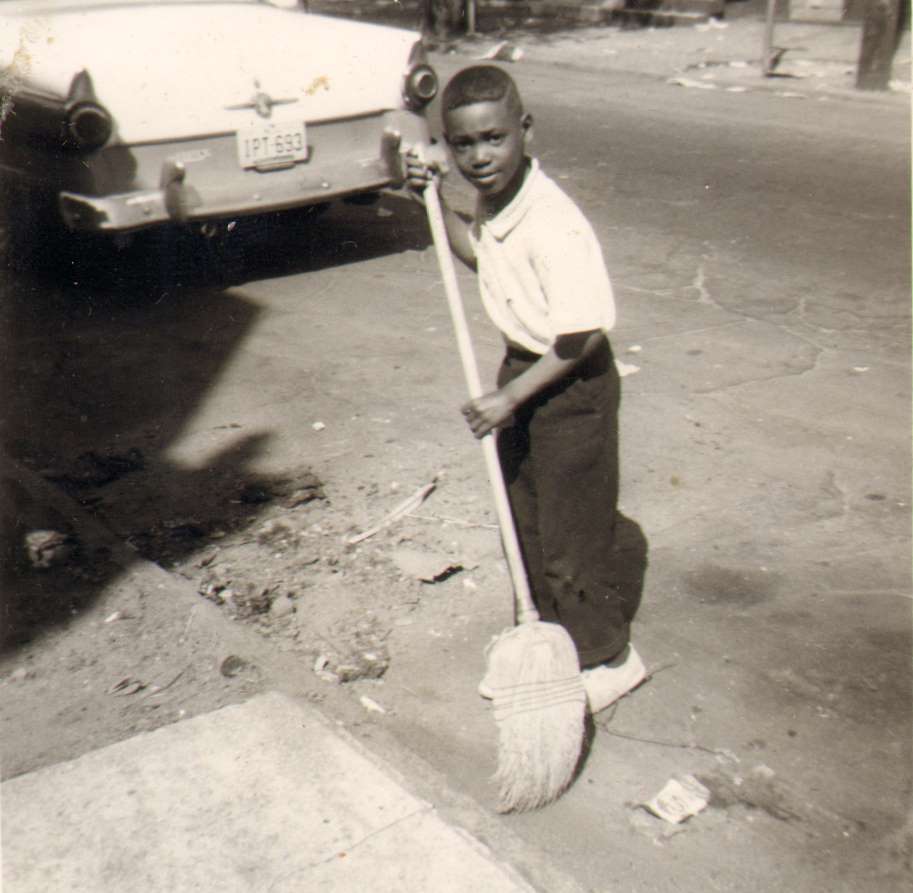 Cassady Elementary School pupil sweeping the street, May 1964 cleanup