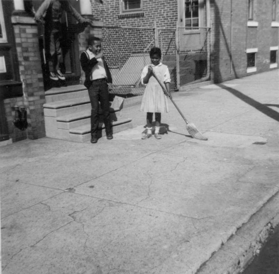 Cassady Elementary School pupils sweeping the sidewalk, May 1964 cleanup