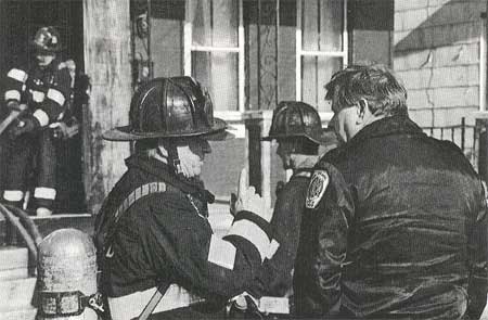 Chief Fire Marshal Herb Leary interviewing fire fighters or helping stretch the first line