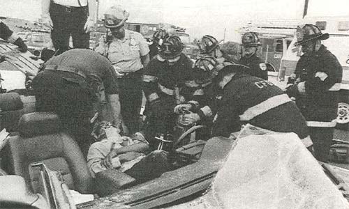 Camden fire fighters and EMS Personnel work to free a victim from a crushed car, Admiral Wilson Boulevard, May 17, 1997
