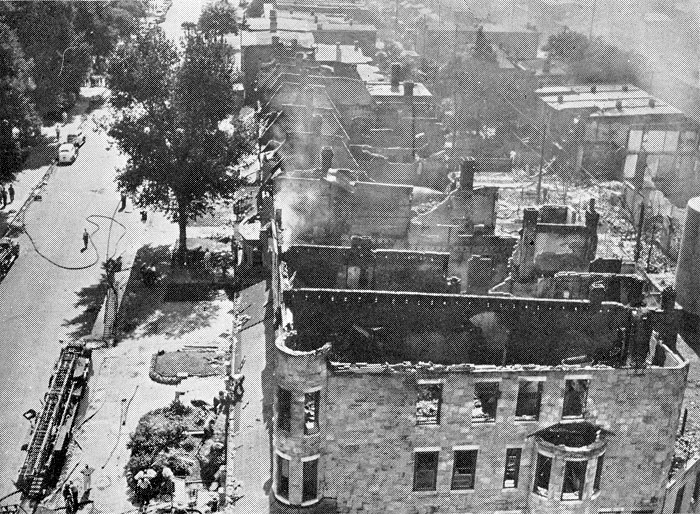 Firemen are shown attempting to check flames which destroyed this row of buildings along Cooper Street