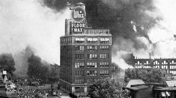 Firemen are shown attempting to check flames which destroyed this row of buildings along Cooper Street