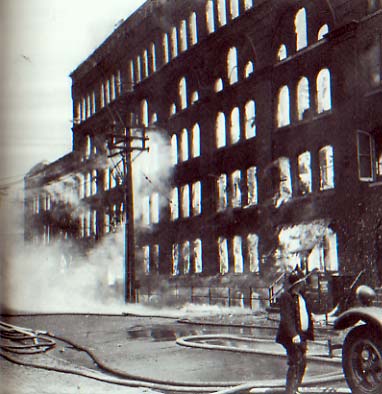The Hollingshead factory fully involved, firefighter in foreground, Camden, NJ, July 30, 1940
