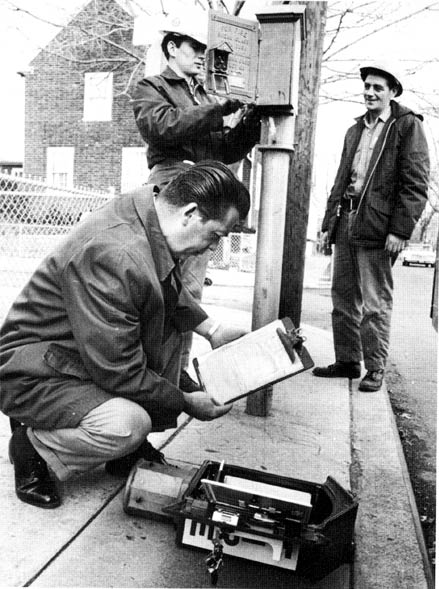 Installing new street boxes in the Fairview section, January 1966 — Michael Speno, Superintendent of the Electrical Bureau, with Lineman John R. Smith and Foreman Bo Jones