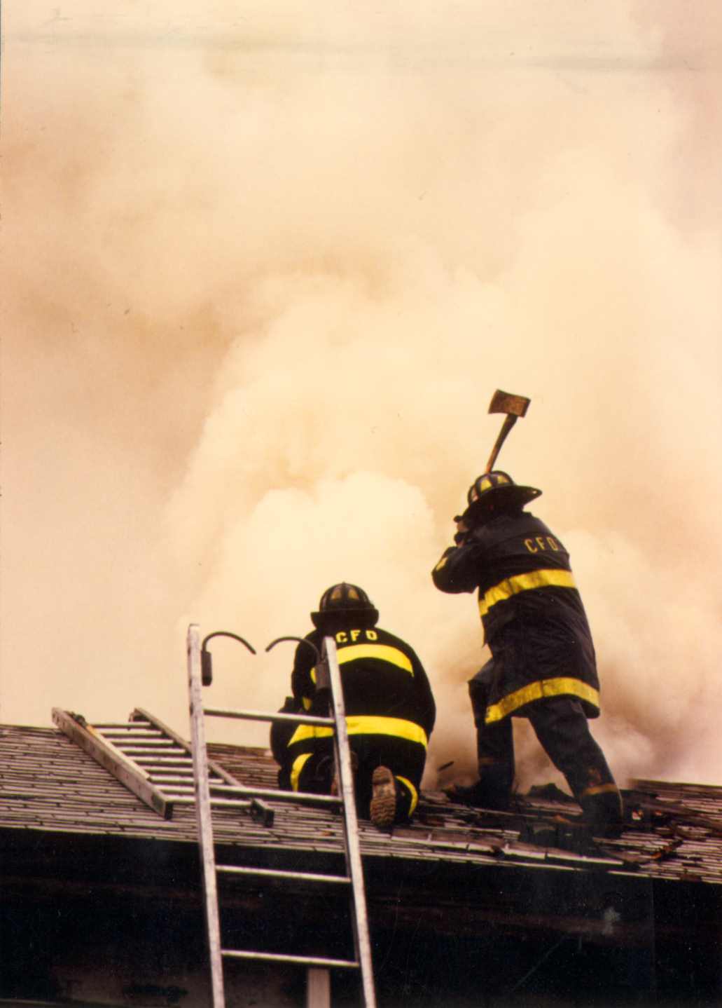 Men of the Hook and Ladder Company operating above the fire while opening the roof of a burning building, Ladder Company 3 in East Camden, circa 1990