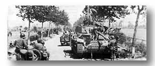 On the second day of the battle, units of the 45th Division pass a knocked-out enemy tank near the 36th Division CP