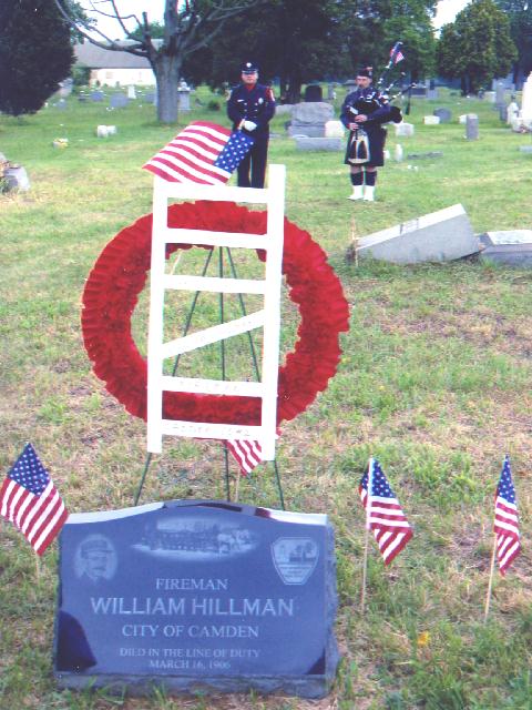 Honor guard Camden FF Melendez standing guard as Captain David Dilks plays the bagpipes at dedication of headstone for Fireman William Hillman
