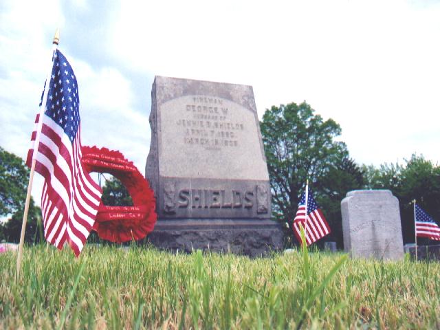 Flags and wreath at the grave site of Fireman George Shields