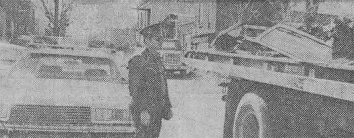 Patrolman Bob Lemayski guards truck laden with stolen auto parts discovered at city-owned garage, January 1982