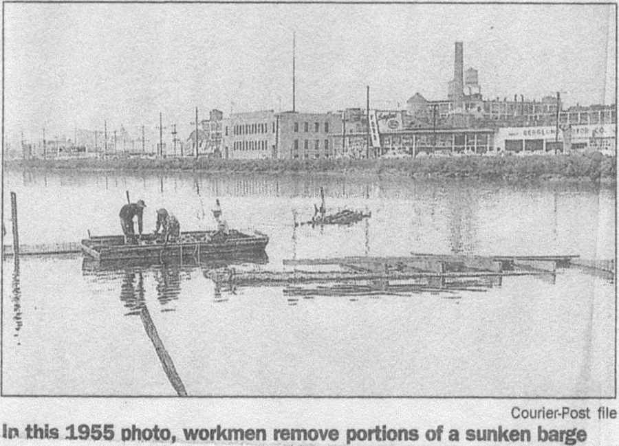 In this 1955 photo, workmen remove portions of the sunken barge — Courier-Post file