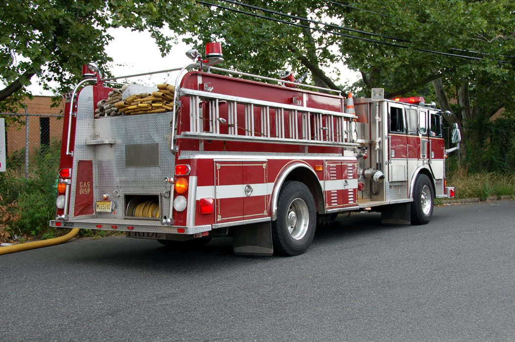 The building where the fire was can be seen behind the apparatus and chain-link fence