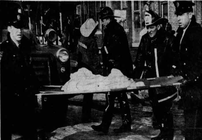 Photo of firefighters carrying shroud-covered body