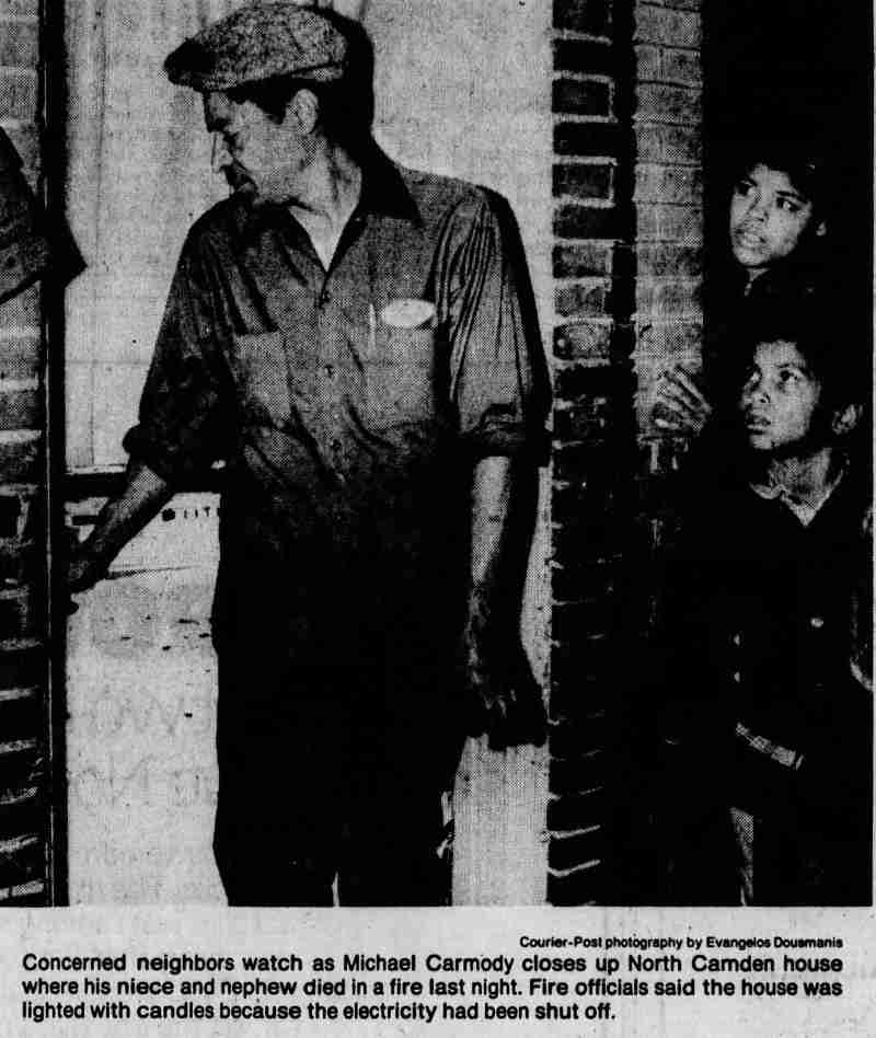 Concerned neighbors watch as Michael Carmody closes up North Camden house, November 1979