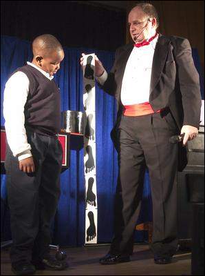 Abdul-Jabbar Ramos assists magician Dennis Michel with a trick at Assumption School in Atco