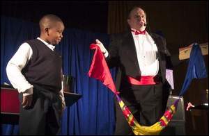 Abdul-Jabbar Ramos watches as magician Dennis Michael performs a scarf trick