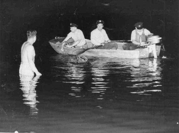 Harrison McNair of Fire Rescue Company 1 helps rescuers in boat look for body of Donna Binder