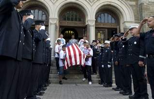 The flag-draped coffin of 9-year-old Jacob Rosa is carried down the steps of Holy Name Catholic Church in Camden and past saluting members of the Camden Fire Department on Saturday