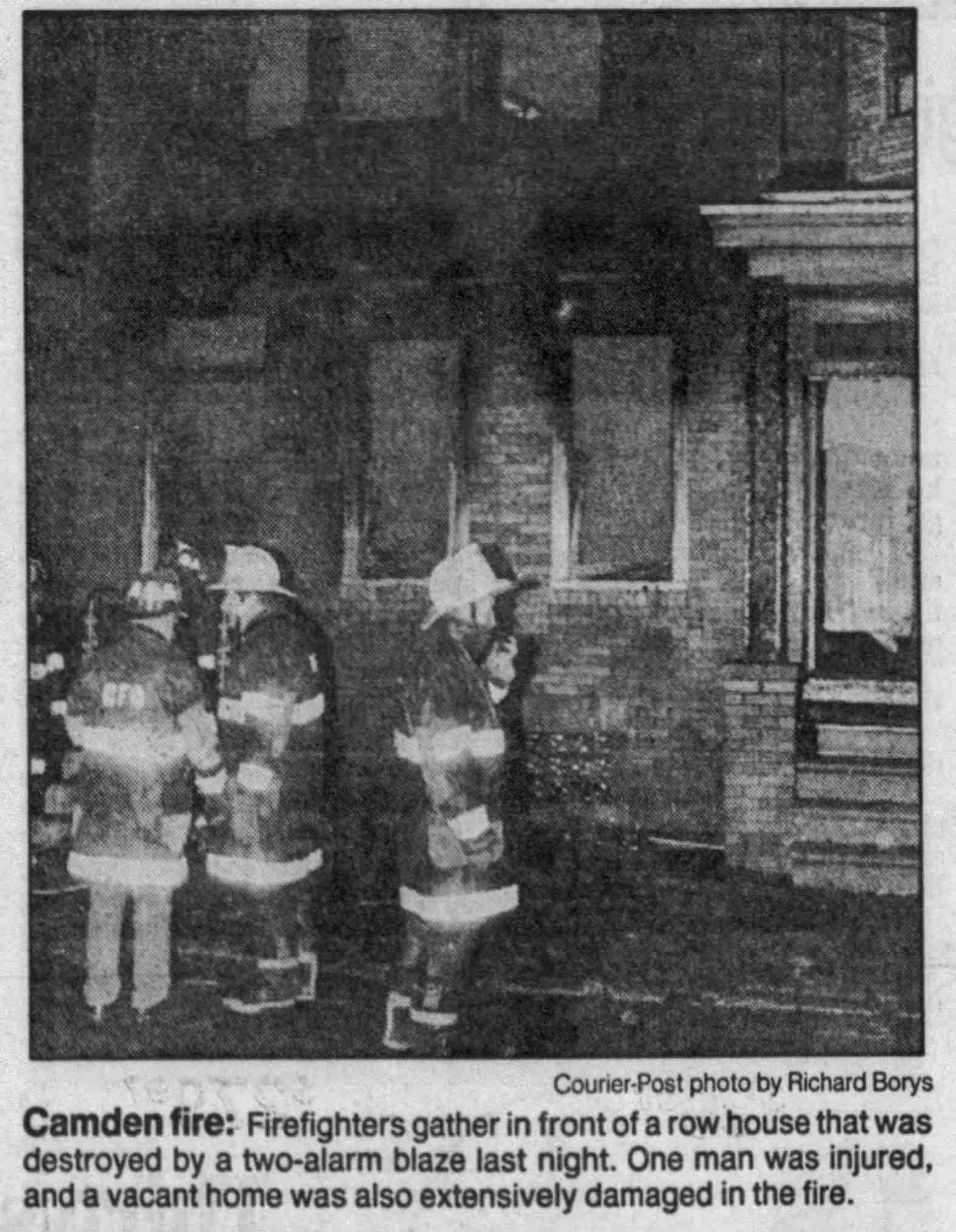 Firefighters in front of row house destroyed at 1143 Sheridan Street, Camden, December 1989