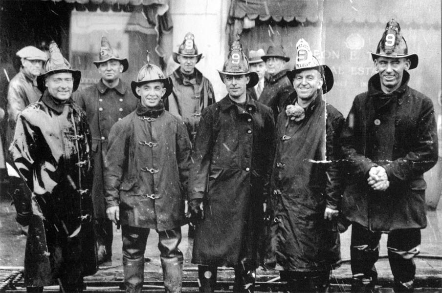 Engine Company 9 firefighters together following a fire on a rainy night in December 1928