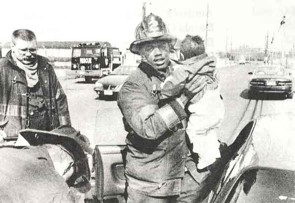 Camden Fire Fighter Jesse Flax with one year old Alexus Lindsey, 1997