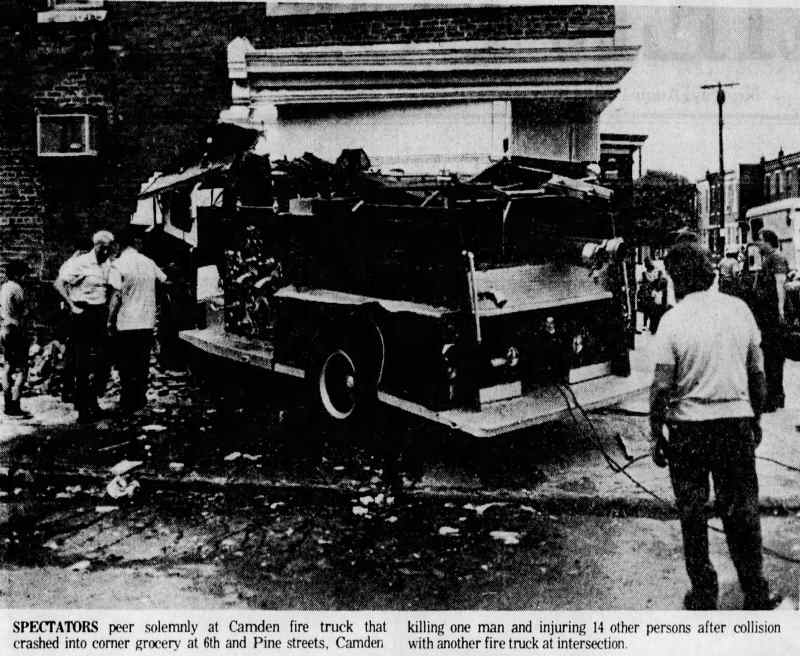 Spectators peer at Camden fire truck that crashed into corner grocery at 6th and Pine Streets