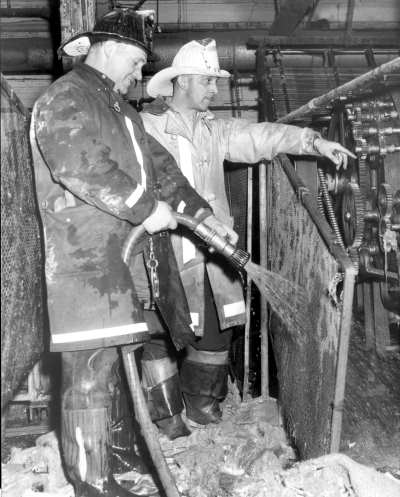 Unknown firefighter and District Chief Theodore Primas after fire at Bender Brothers, 250 Atlantic Avenue, December 18, 1961