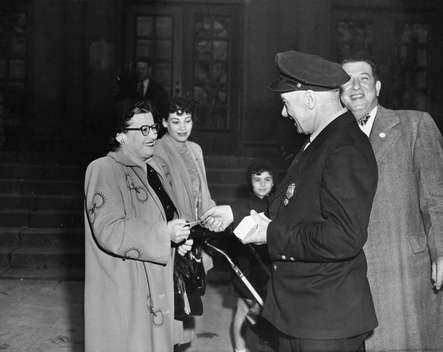 William Comerford passing out circulars in front of the Alfred Cramer School, 1949