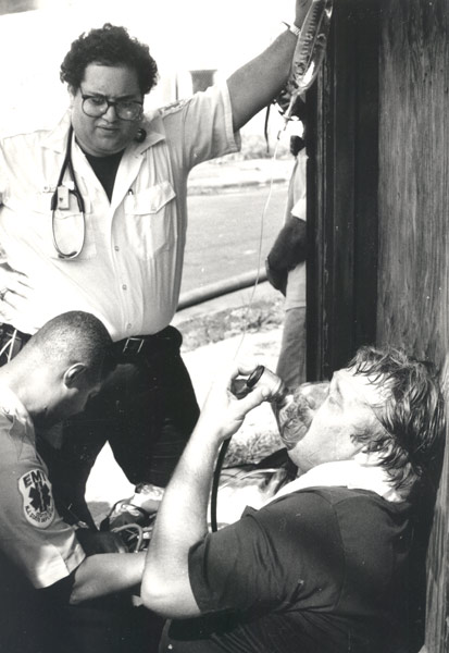 Camden firefighter Paul Matyjasik getting oxygen after fire at 501-519 Jackson Street, June 30, 1990